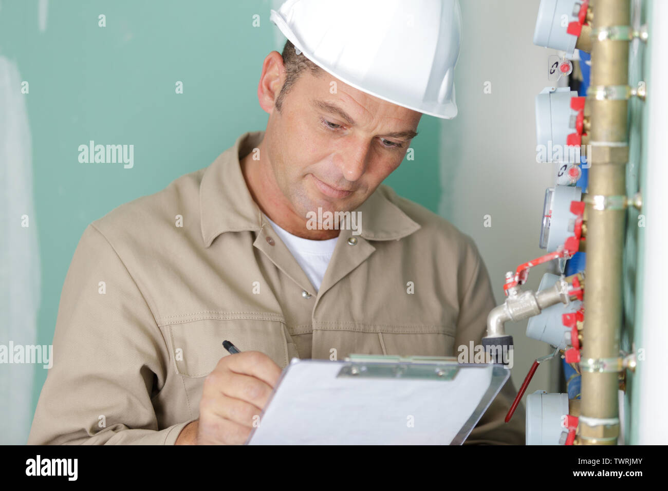 technician reading the water meter to check consumption Stock Photo Alamy