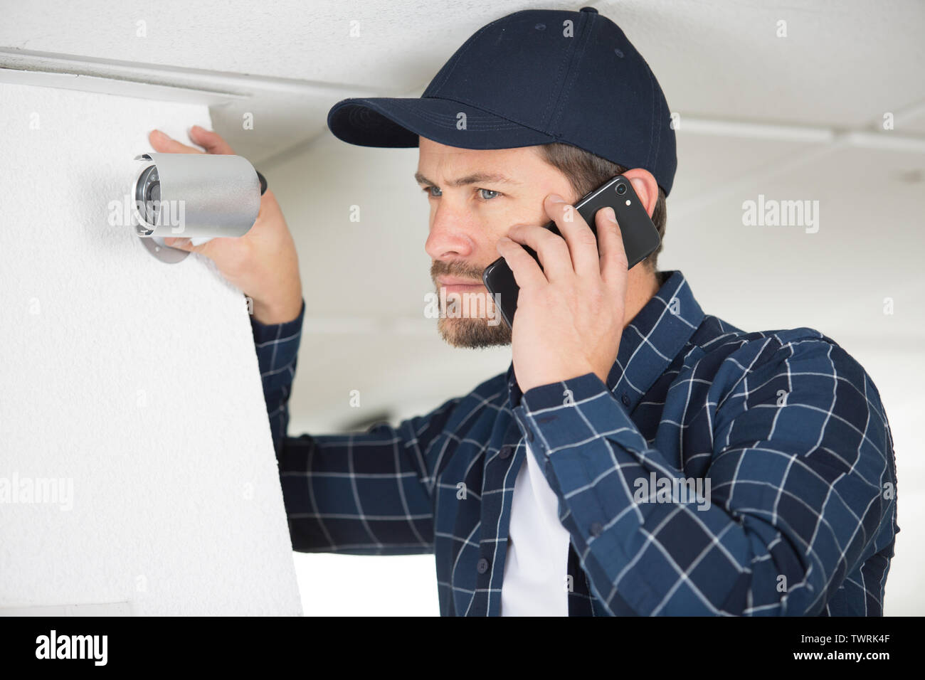 young technician encountering a problem while adjusting cctv camera Stock Photo