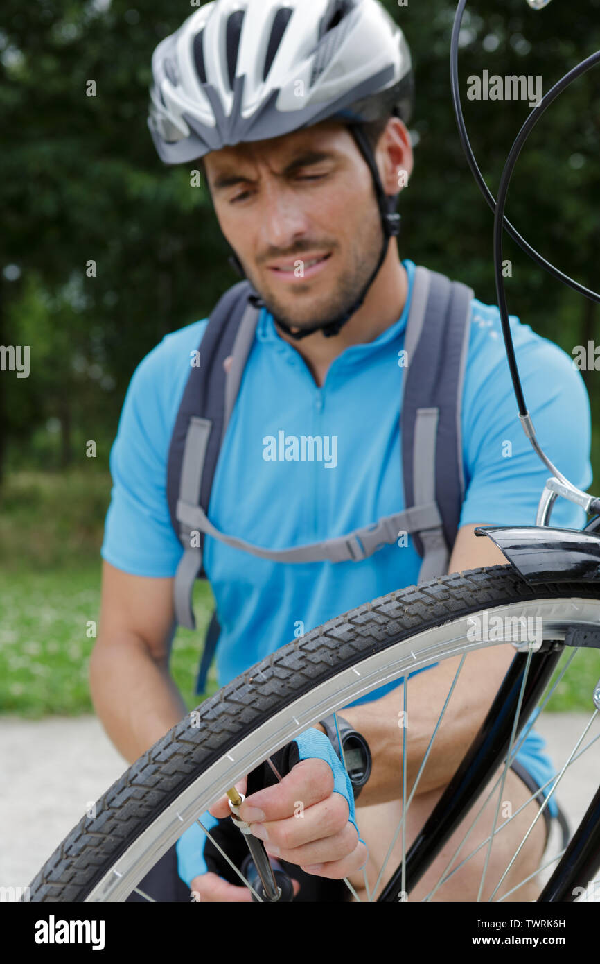 portrait of smiling male cyclist repairing his bike Stock Photo - Alamy