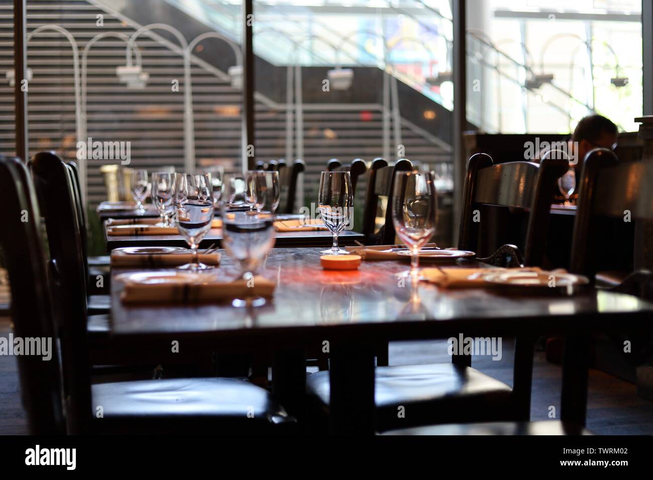An empty table inside a restaurant with wine glasses and napkins set Stock Photo