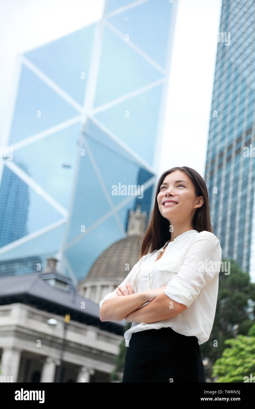 Asian business woman confident outdoor in Hong Kong standing proud in suit cross-armed in business district. Young mixed race female Chinese Asian / Caucasian female professional in central Hong Kong. Stock Photo