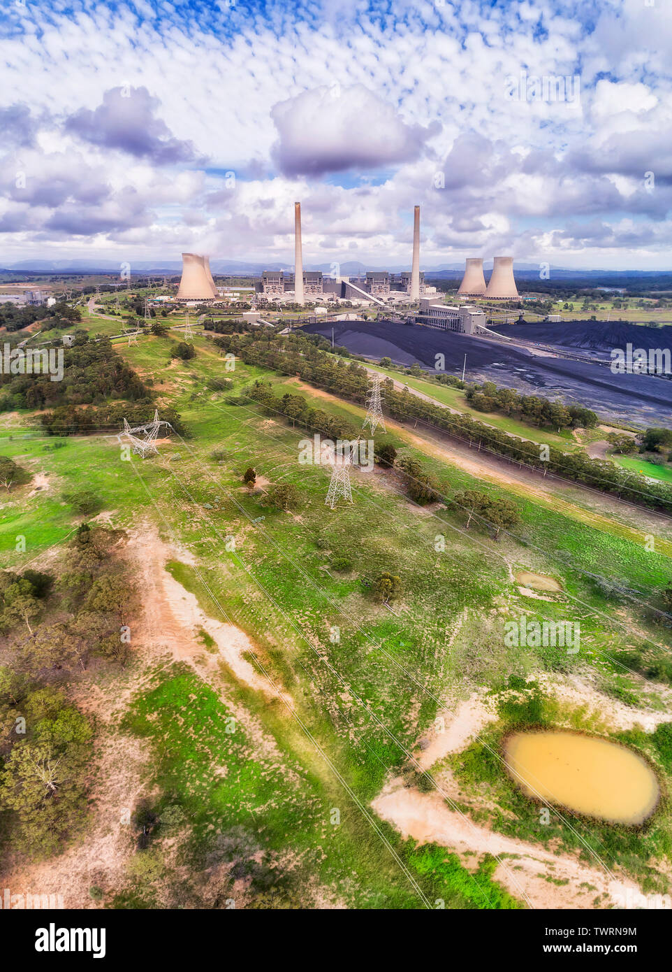 Generation of electrisity by burning black coal fossil fuel at Bayswater power station in Liddell. Vertical aerial panorama over ground landscape up t Stock Photo