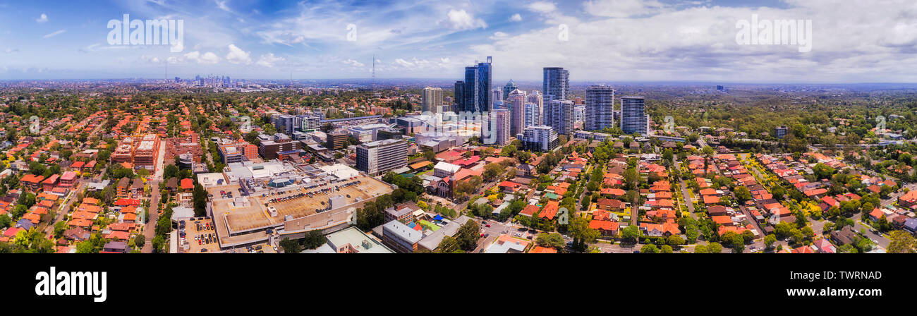 Urban panorama of SYdney city in a distance on the horizon behind Chatswood CBD surrounded by residential streets and houses on a sunny day. Stock Photo