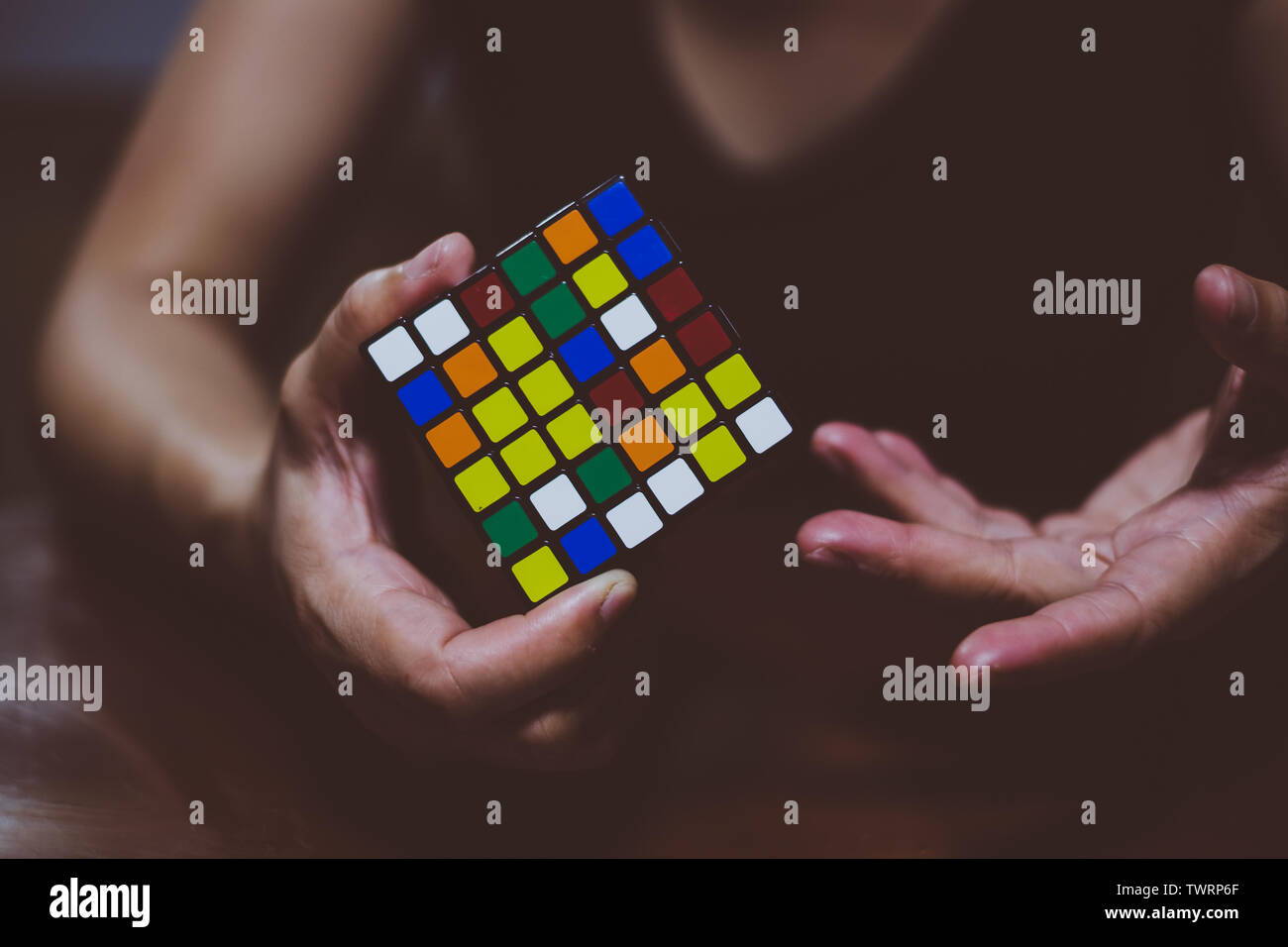BANGA, PH– MAY 30, 2019: Rubik's Cube was invented in 1974 by Hungarian sculptor and professor of architecture Erno Rubik. Hands of a young lady tryin Stock Photo