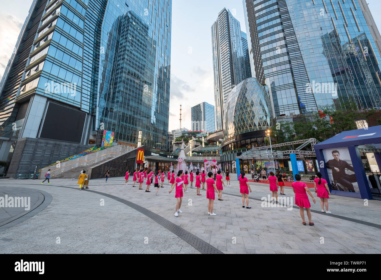 Chengdu, Sichuan province, China - June 6, 2019 : Senior women with red outfit practising square dancing in front of Evergrande plaza commercial mall Stock Photo