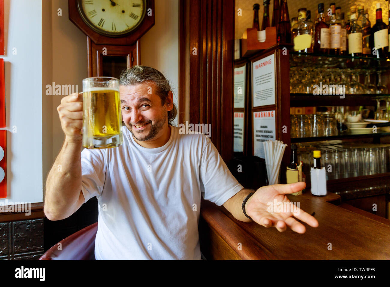 Man drinking beer Side view of handsome man drinking beer while sitting