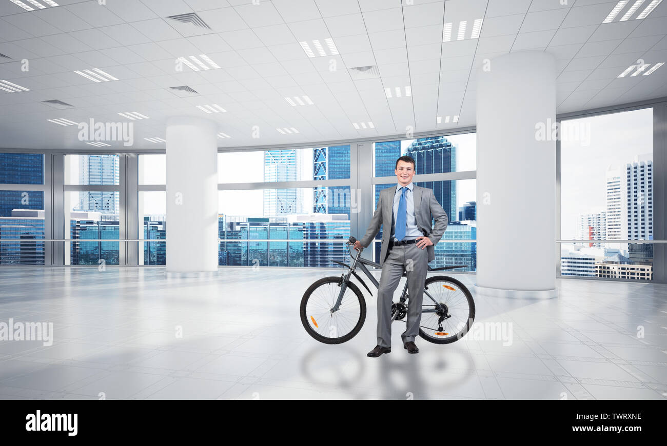 Young Man Wearing Business Suit And Tie With Bike Standing At