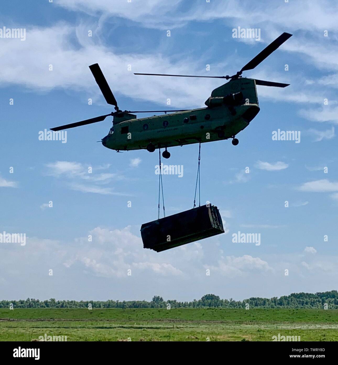 A U.S. Army CH-47 Chinook from the 12th Combat Aviation Brigade is en route to deliver raft section to engineers waiting on the Danube River in Bordusani, Romania June 20, 2019 during Saber Guardian 19. Saber Guardian 19 is an exercise co-led by the Romanian Joint Force Command and U.S. Army Europe, taking place from June 3 - 24 at various locations in Bulgaria, Hungary and Romania. Saber Guardian 19 is designed to improve the integration of multinational combat forces. (U.S. Army photo by Cpt. Erica Mitchell) Stock Photo
