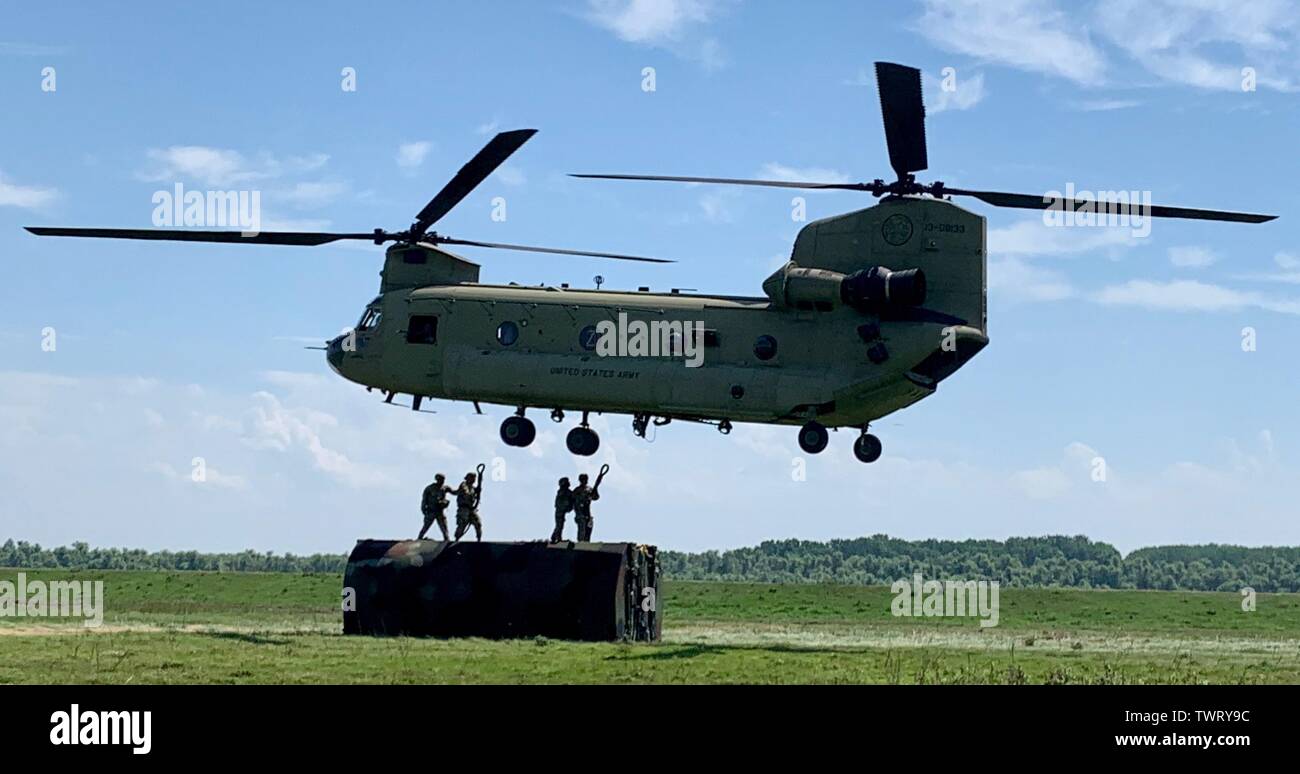 Soldiers from the 50th Multi-Role Bridge Company, 5th Engineer Battalion, 4th Maneuver Enhancement Brigade attach raft section to a CH-47 Chinook from the 12th Combat Aviation Brigade in Bordusani, Romania June 20, 2019 during Saber Guardian 19. Saber Guardian 19 is an exercise co-led by the Romanian Joint Force Command and U.S. Army Europe, taking place from June 3 - 24 at various locations in Bulgaria, Hungary and Romania. Saber Guardian 19 is designed to improve the integration of multinational combat forces. (U.S. Army photo by Cpt. Erica Mitchell) Stock Photo