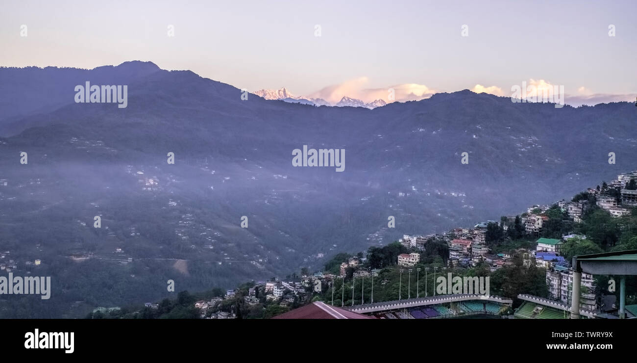 Landscape,Gangtok city,,rolling,valley,in west,Paljor Stadium,sun rise,lifting,fog, from Valley,,Mt.Kanchendzonga,dazzling,in,Morning Sun light,Sikkim Stock Photo