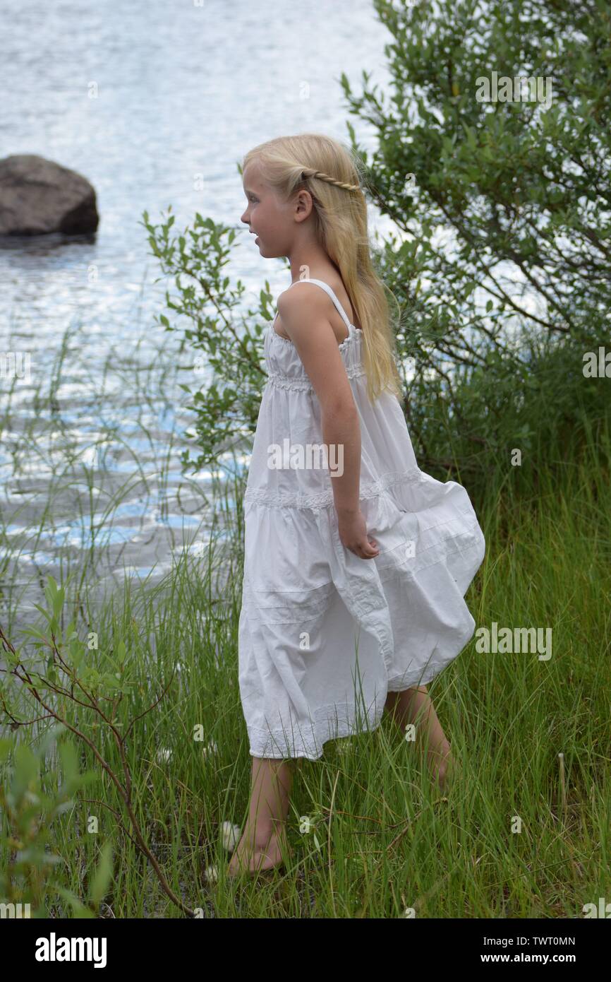Girl in white dress by the water Stock Photo - Alamy