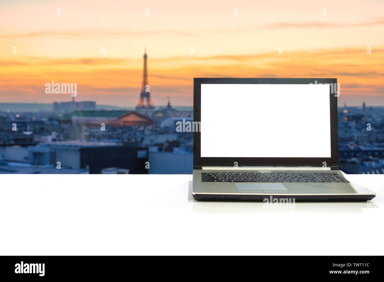 Laptop On White Desk With Blurred Scene Eiffel Tower In Paris At