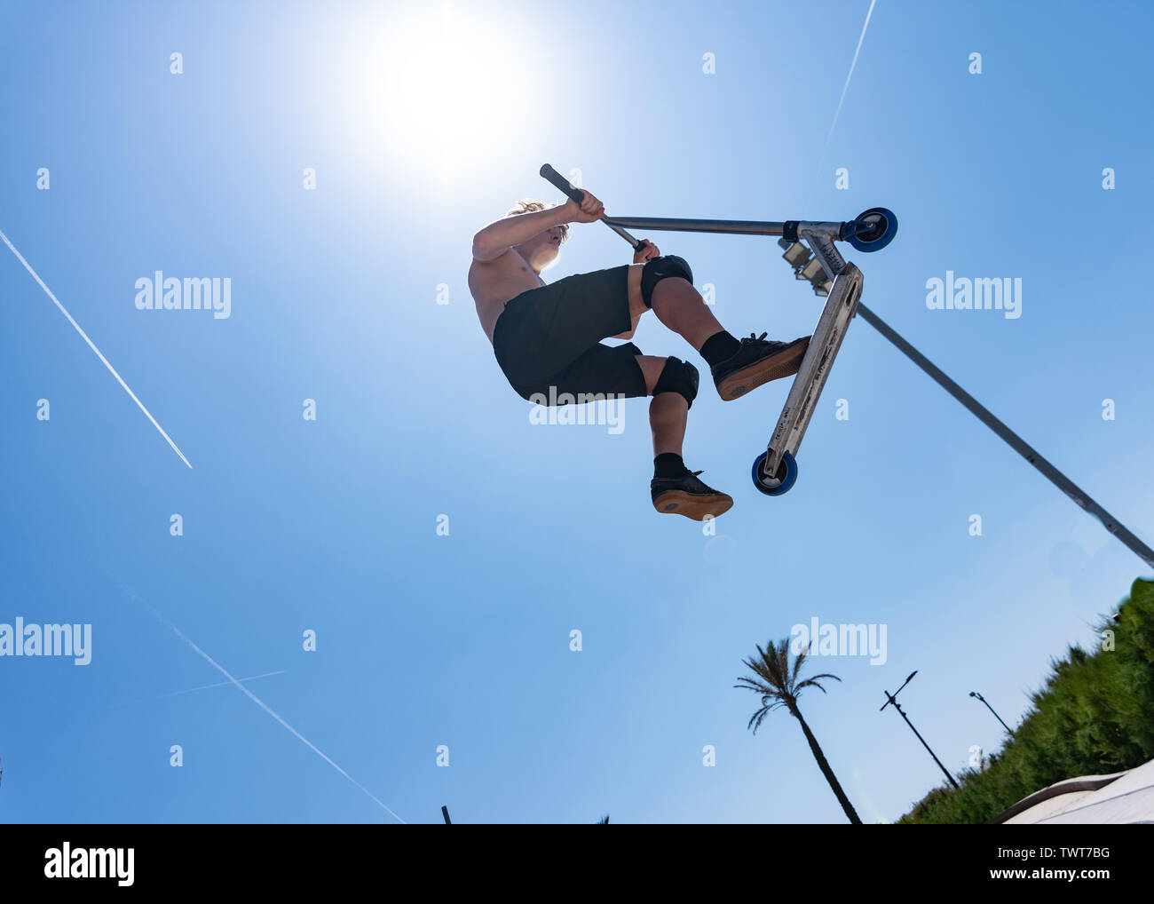 Boy doing sport with scooter in skate park Stock Photo