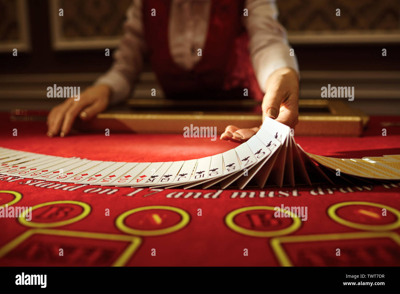 Kaszinói krupié kártyákat kever az asztalon