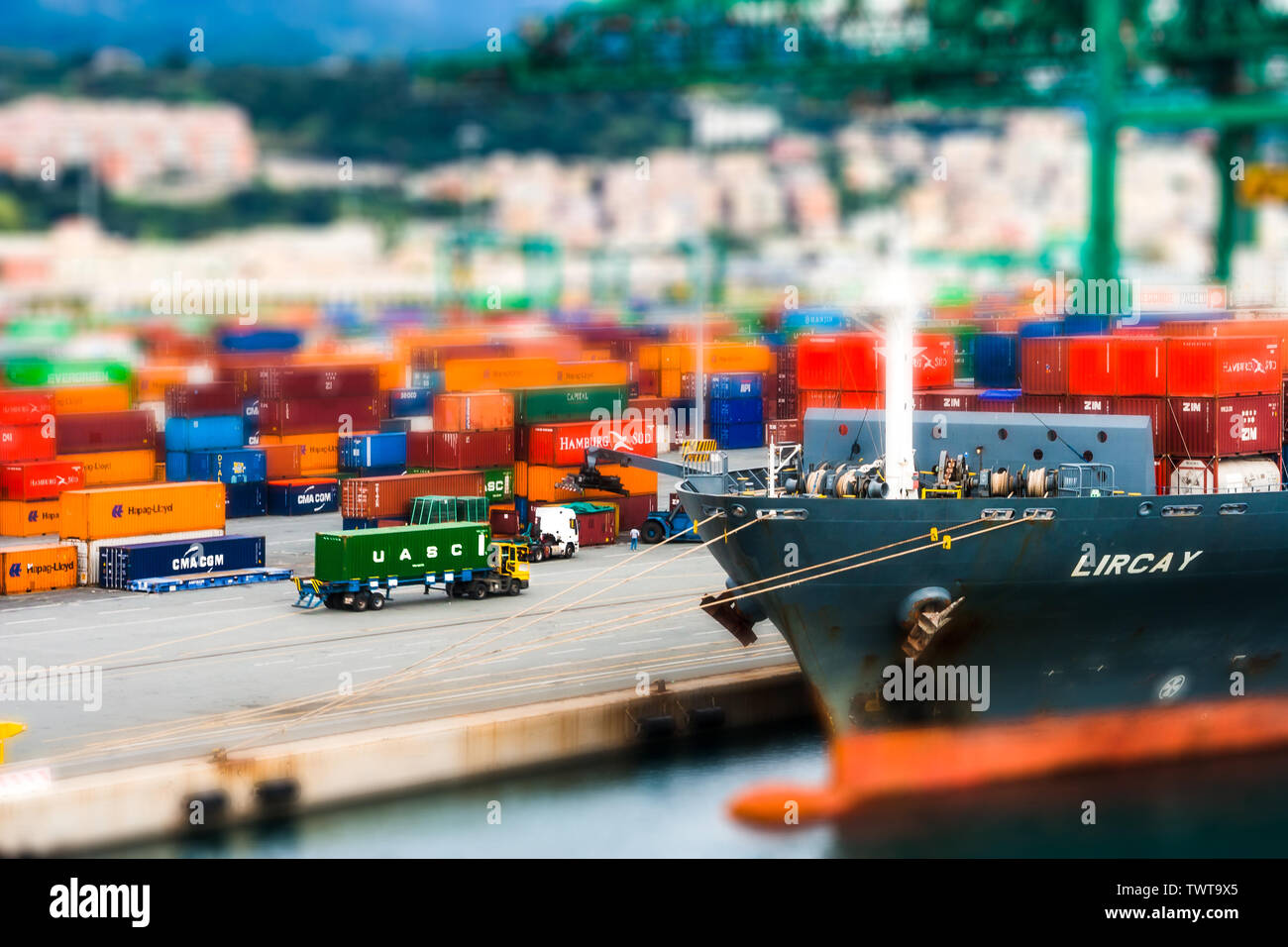 A miniature model of a port scene in Genoa, italy. Trucks are moving containers to be loaded onto a ship. Stock Photo
