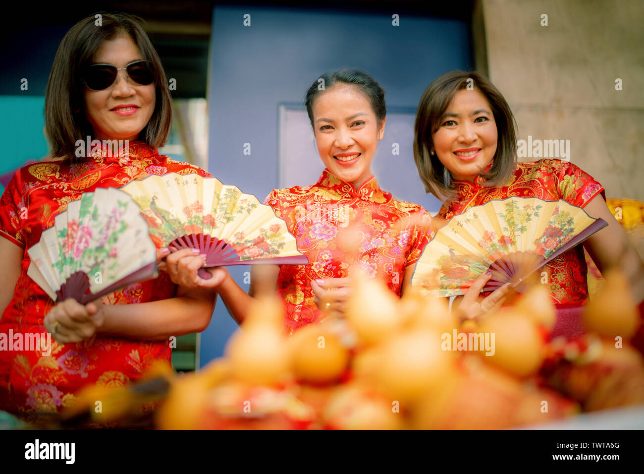 group of asian woman wearing chinese tradition clothes toothy smiling face happiness emotion and hand sign i love you Stock Photo