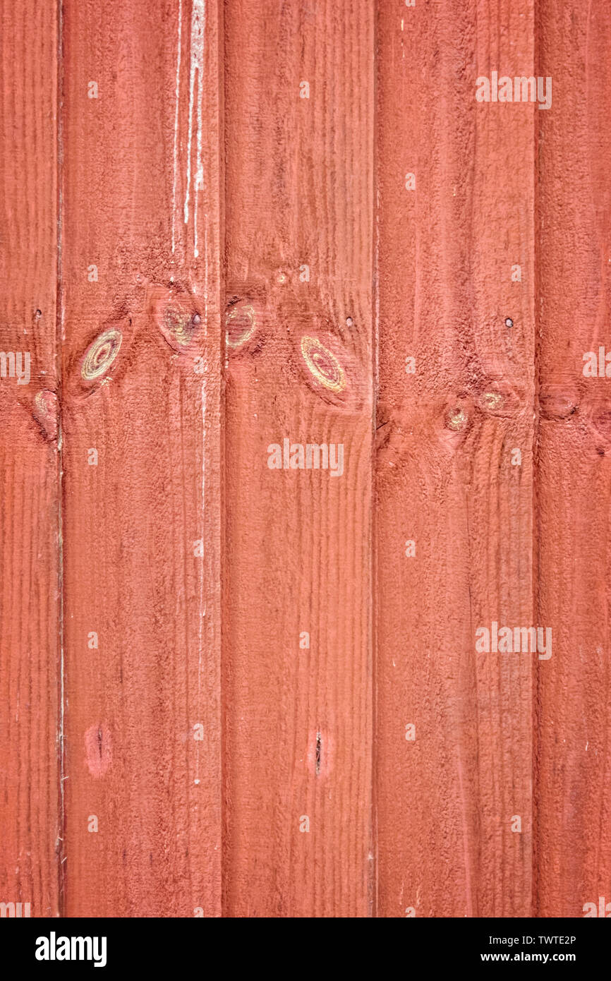 Semi-abstract vertical, red-stained, wooden fence slats; portrait format. Stock Photo