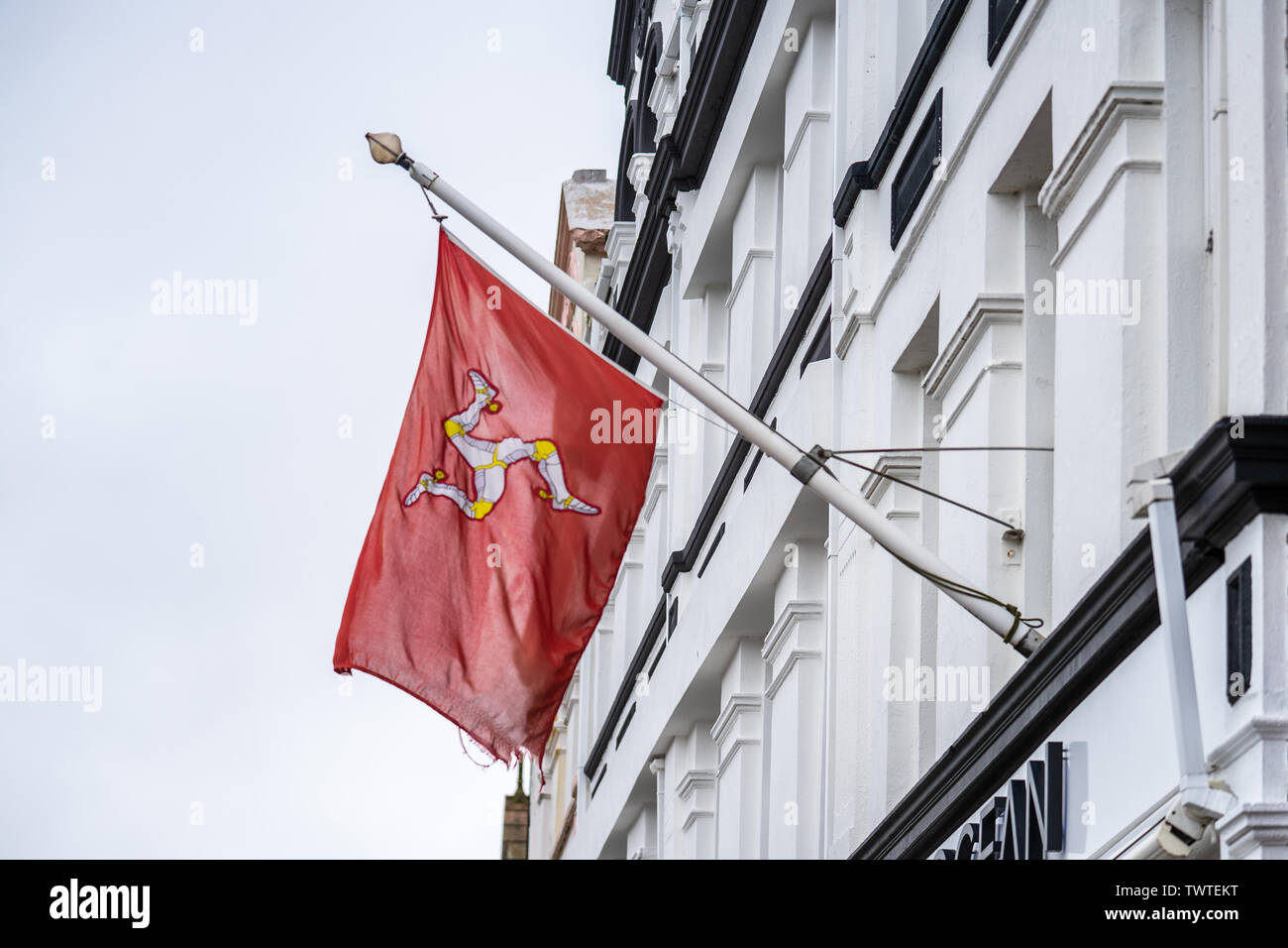 The flag of the Isle of Man or flag of Mann is a triskelion, composed of  three armoured legs with golden spurs, upon a red background Stock Photo -  Alamy