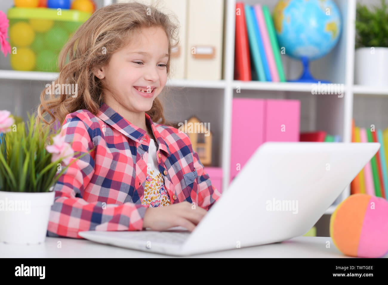Portrait of cute little girl using modern laptop Stock Photo - Alamy