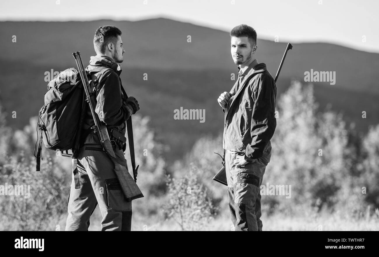 Hunting skills and weapon equipment. How turn hunting into hobby. Friendship of men hunters. Army forces. Camouflage. Military uniform fashion. Man hunters with rifle rifl gun. Boot camp. travel. Stock Photo