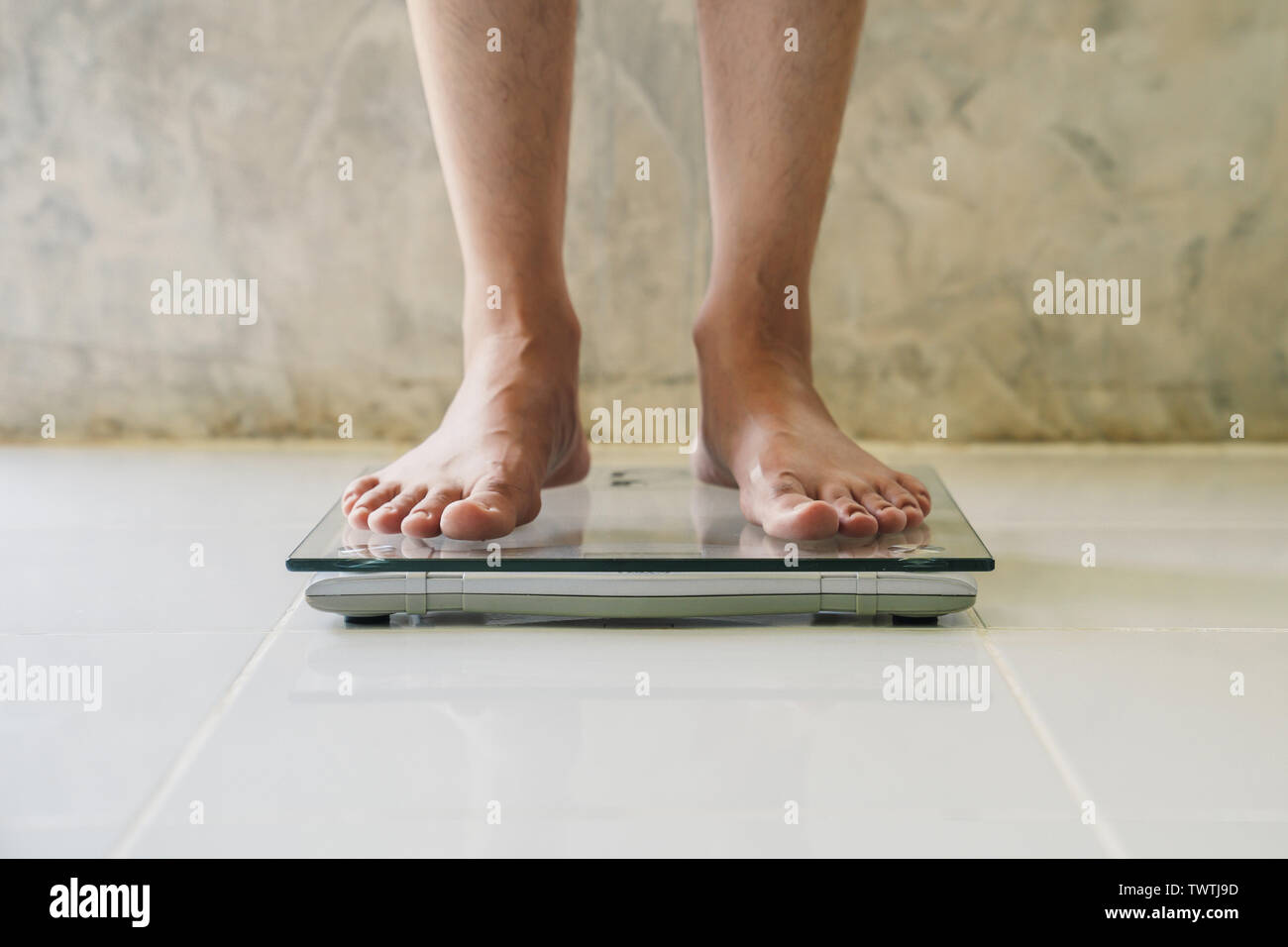 Male on weight scale on floor background, Diet concept. Stock Photo