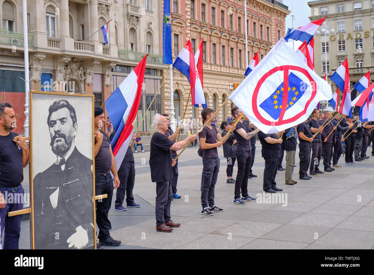 Zagreb, Croatia, June 23, 2019 : HSP lead Right wing political rally , featuring man dressed in black waving Croatian, Black and Anti EU flags Stock Photo