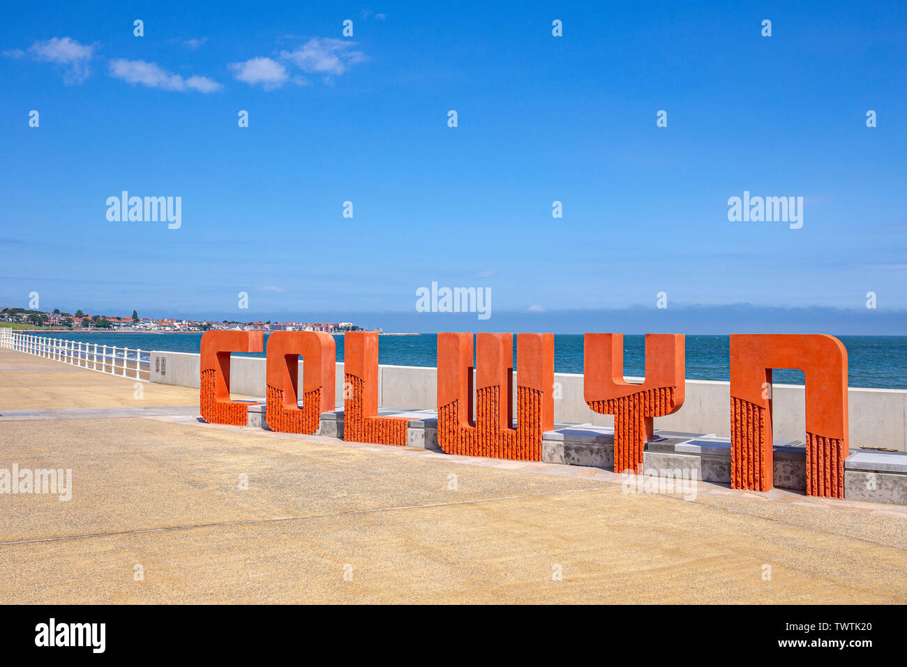Colwyn sign on the promenade in Colwyn Bay with Rhos on Sea in the distance, Wales UK Stock Photo