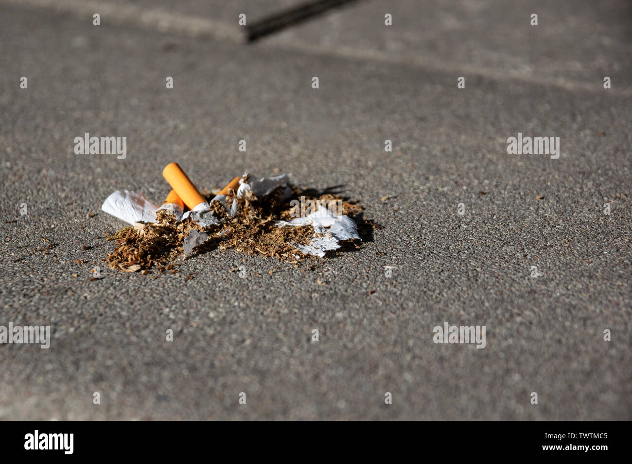 three crushed cigarettes lying on the pavement Stock Photo