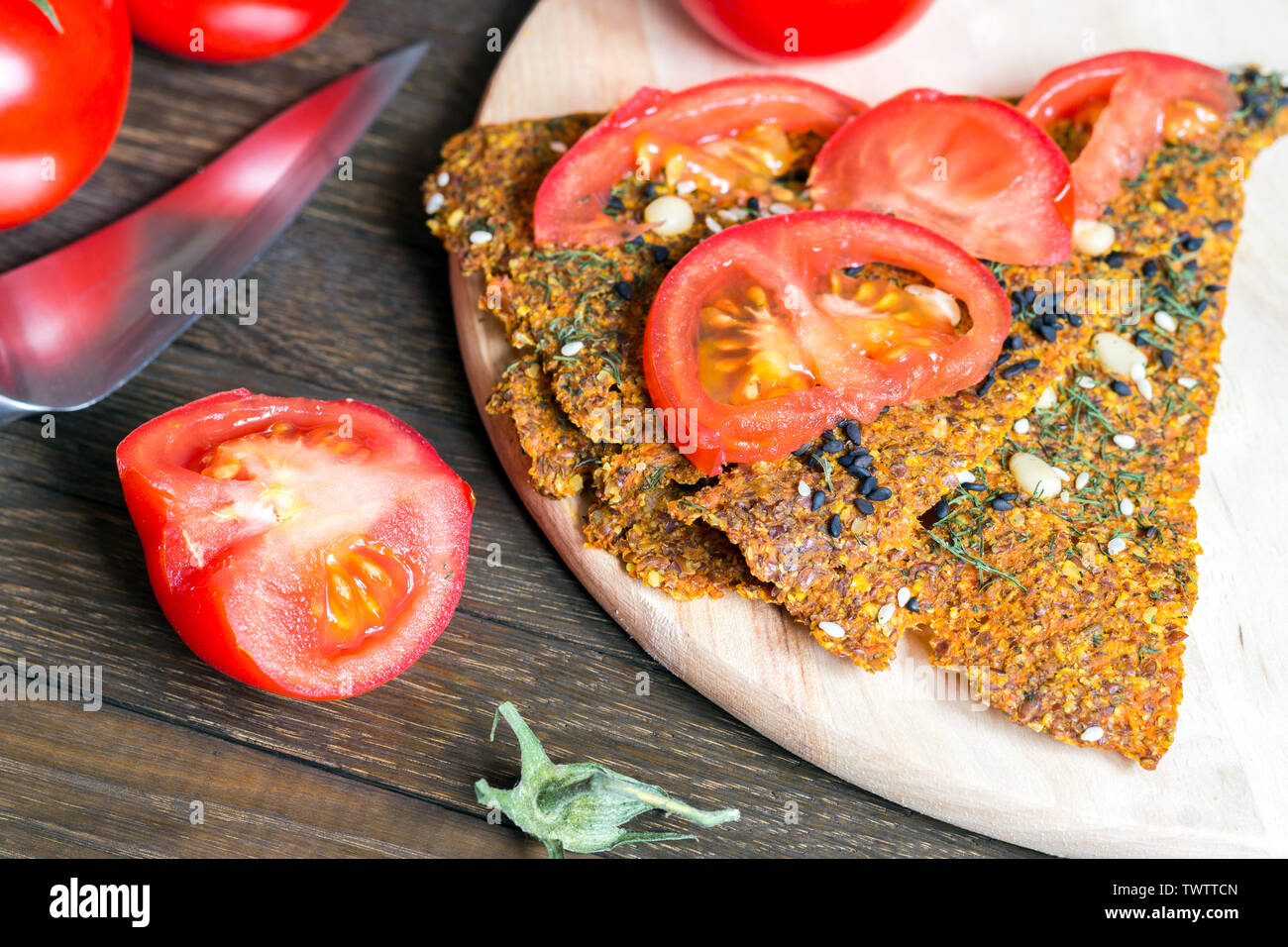 Raw food preparation. Vegan diet. Healthy meal concept. Rustic natural eating. Dried crispbread loaves from carrot, onion and flax, sprinkled with dil Stock Photo