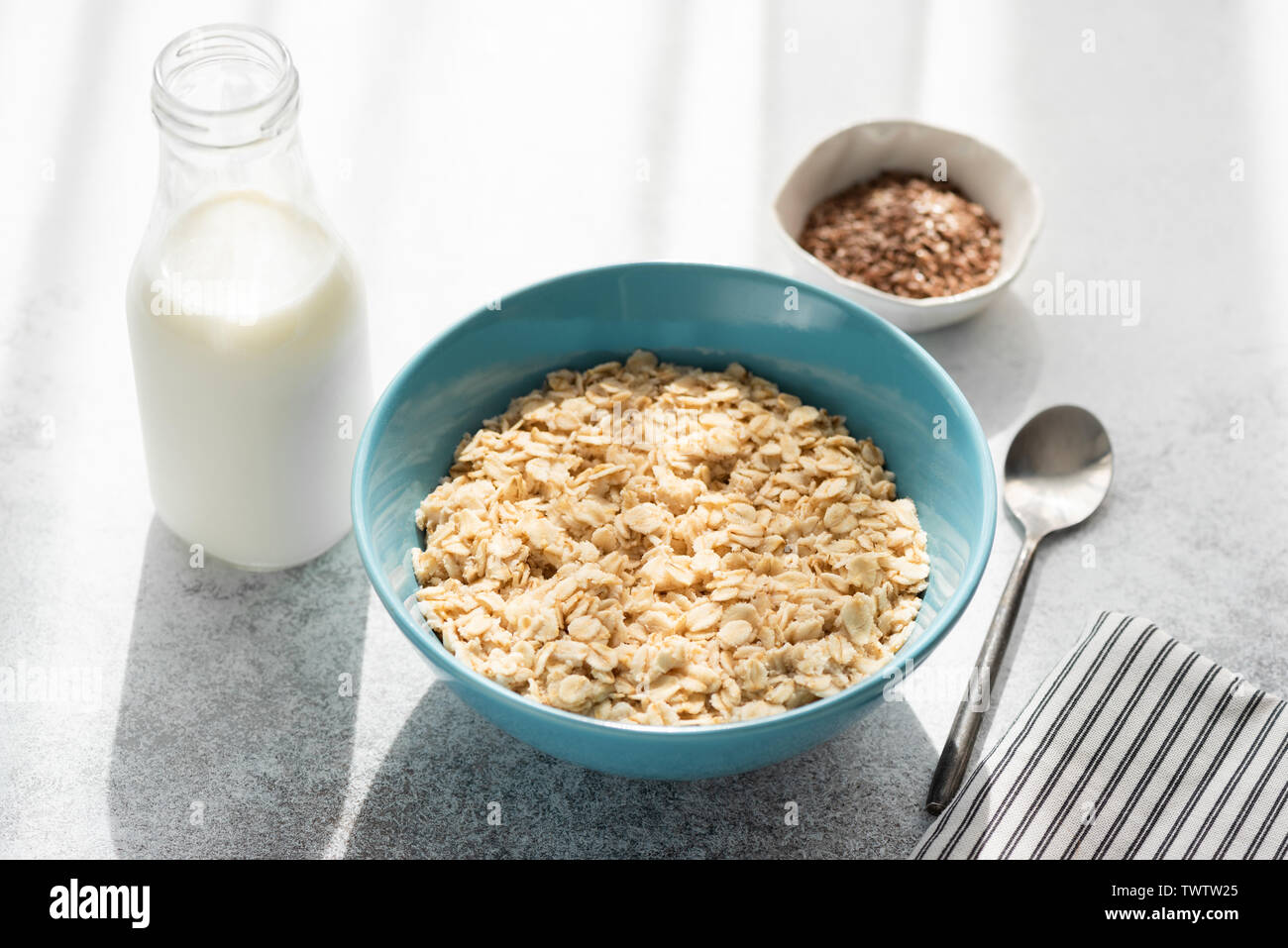 Healthy Breakfast, oatmeal porridge in bowl and bottle of milk. Weight loss, Clean eating concept Stock Photo