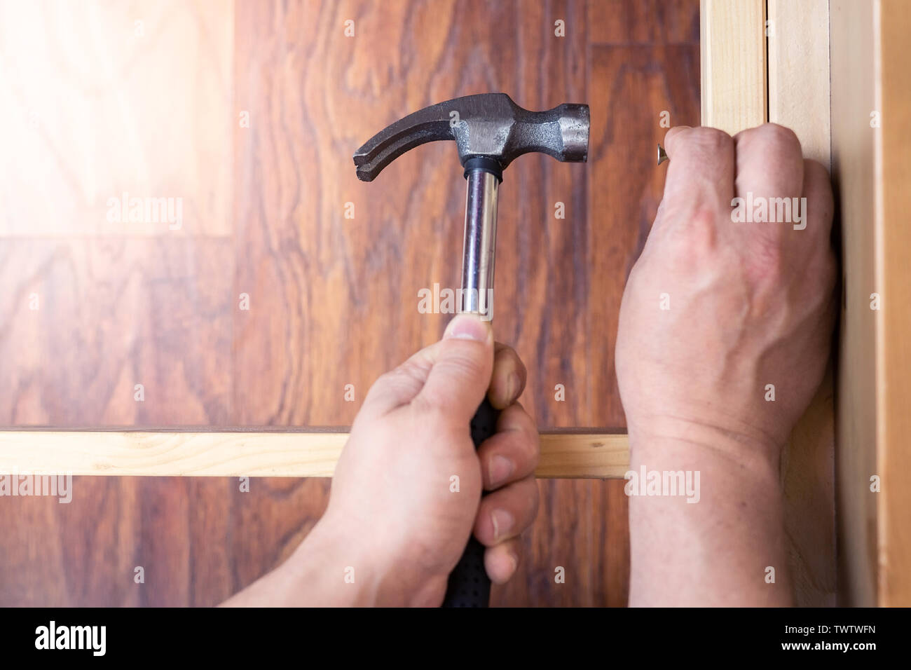 Assembling wooden furniture using a hammer, close up Stock Photo Alamy