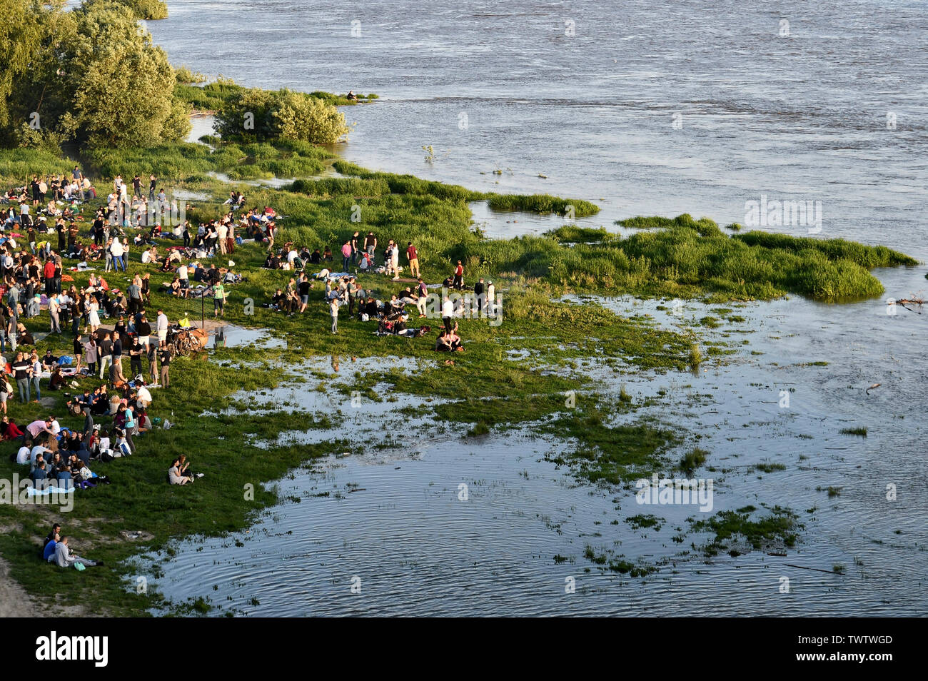 People resting on flooded riverbank, Vistula River, Warsaw, Poland Stock Photo