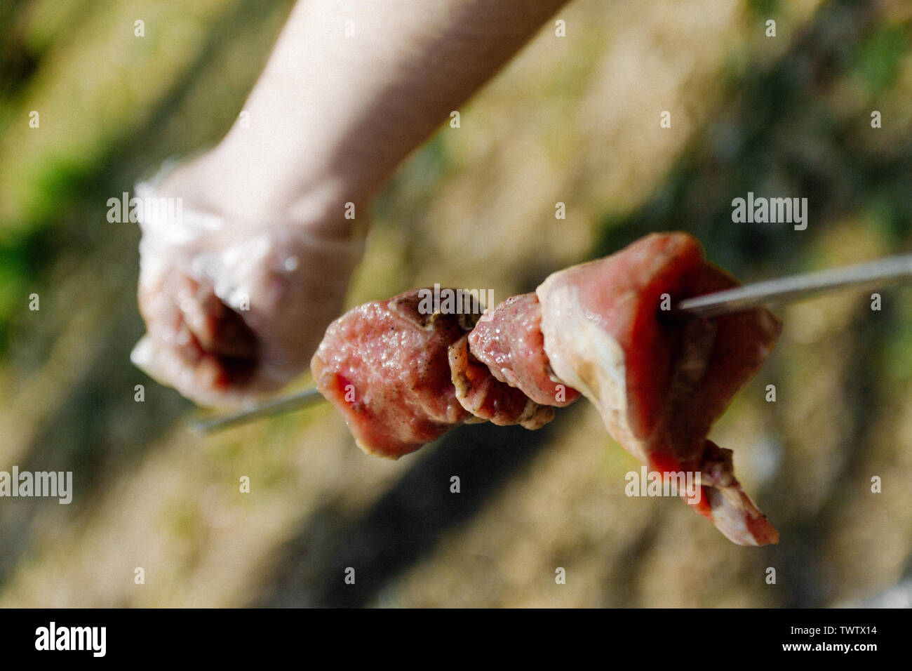 man stringing meat on a skewer. Close-up Stock Photo - Alamy