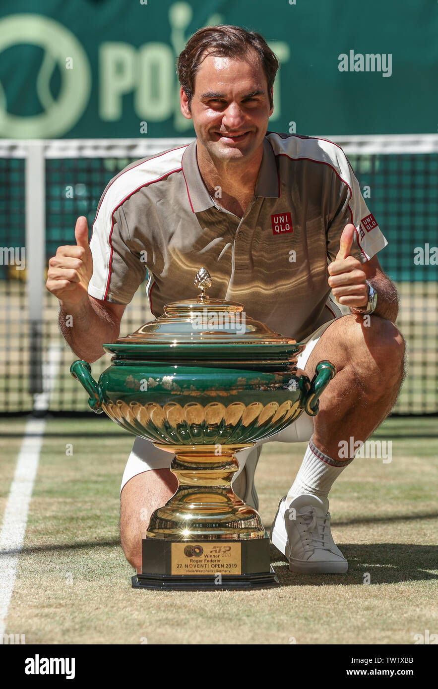 Halle, Germany. 23rd June, 2019. Tennis: ATP-Tour singles, men, final,  Federer (Switzerland) - Goffin (Belgium). The winner Roger Federer kneels  next to the trophy after the award ceremony and keeps his thumbs