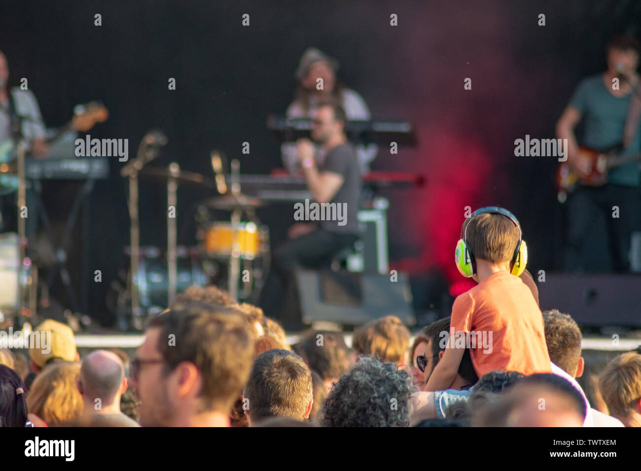Brussels,Belgium - June 22 2019: Boy with noise canceling headset listening to concert by YÔKAÏ at Fete de la Music. Stock Photo