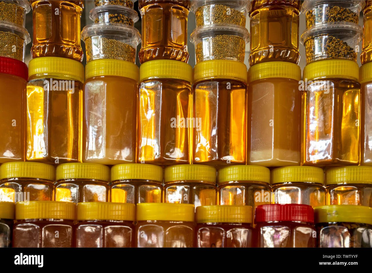 Rows of plastic jars filled with honey and seeds of plants Stock Photo