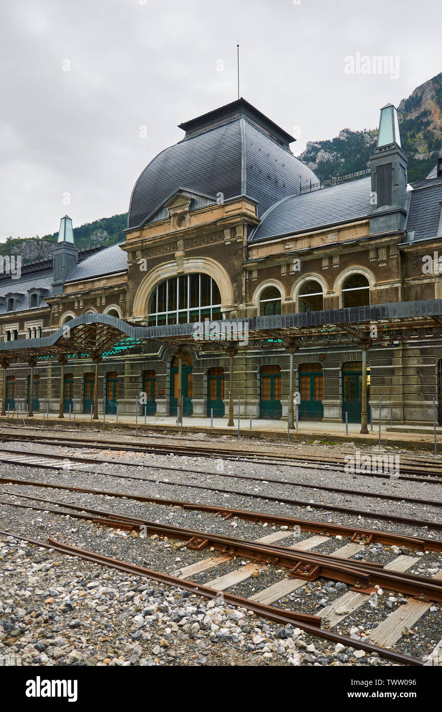 Frontage and entrance of the abandoned Canfranc International railway station and its railway tracks (Pyrenees, Jacetania, Huesca, Aragon, Spain) Stock Photo