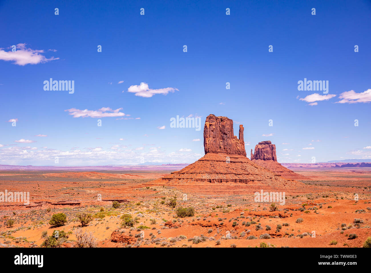 Monument Valley, Navajo Tribal Park in the Arizona-Utah border, United States of America. Red rocks against blue sky background Stock Photo