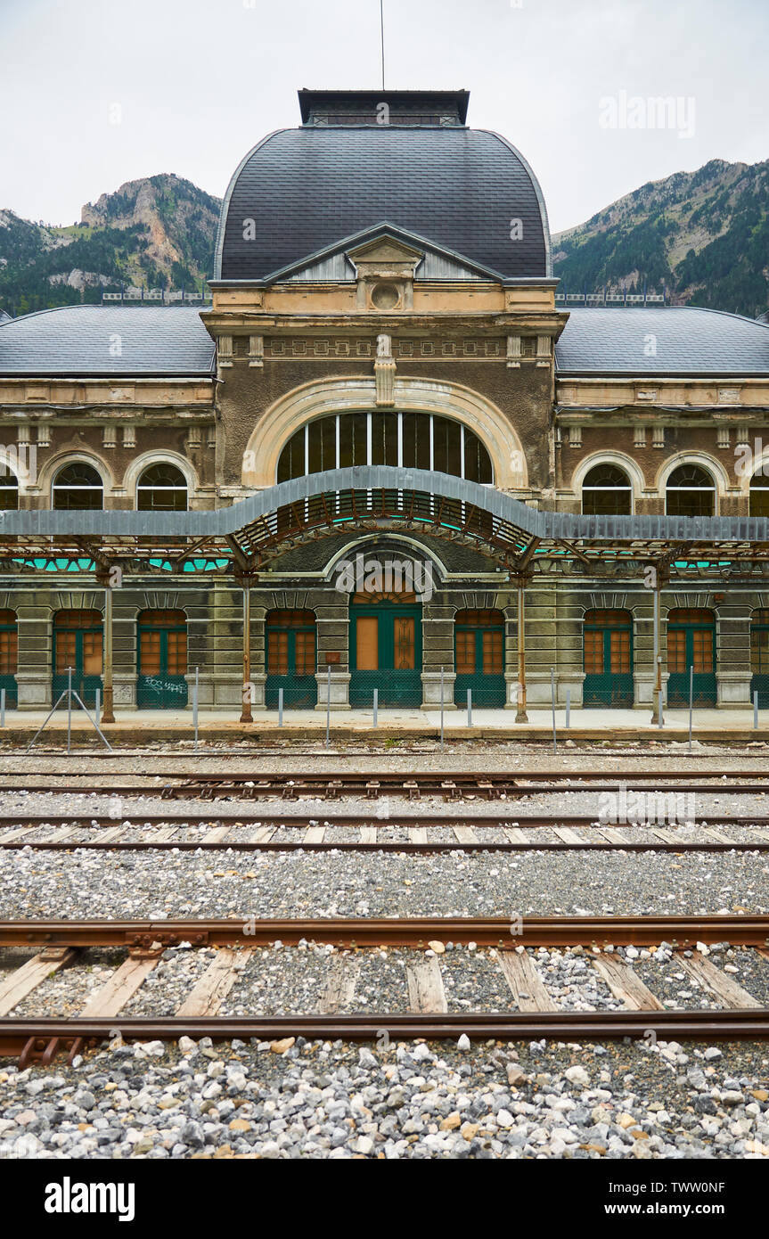 Entrance front view of the abandoned Canfranc International railway station and its railway tracks (Canfranc, Pyrenees, Huesca, Aragon, Spain) Stock Photo