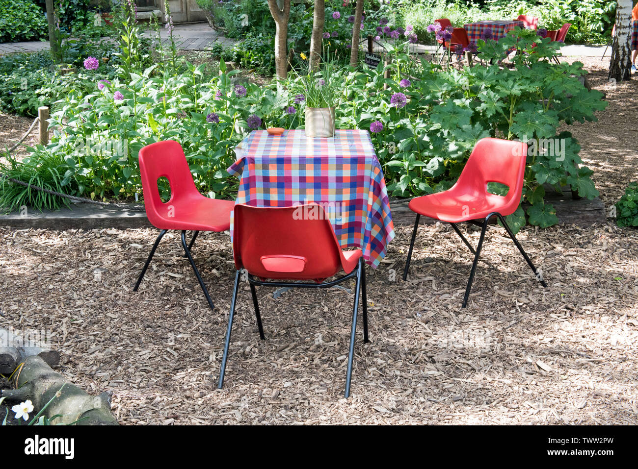 Empty table and red chairs, Dalston Eastern curve Garden, London Borough of Hackney. England, UK Stock Photo