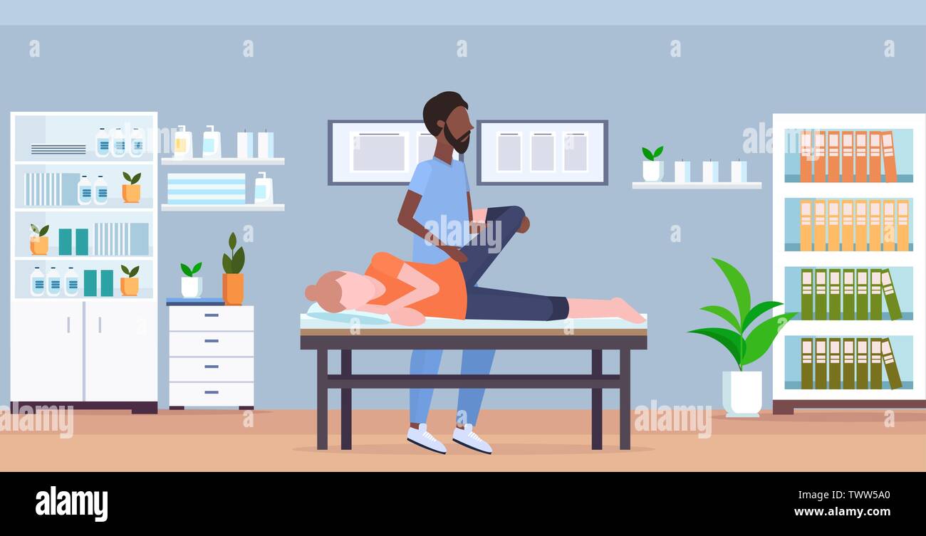 girl lying on massage bed african american masseur therapist doing