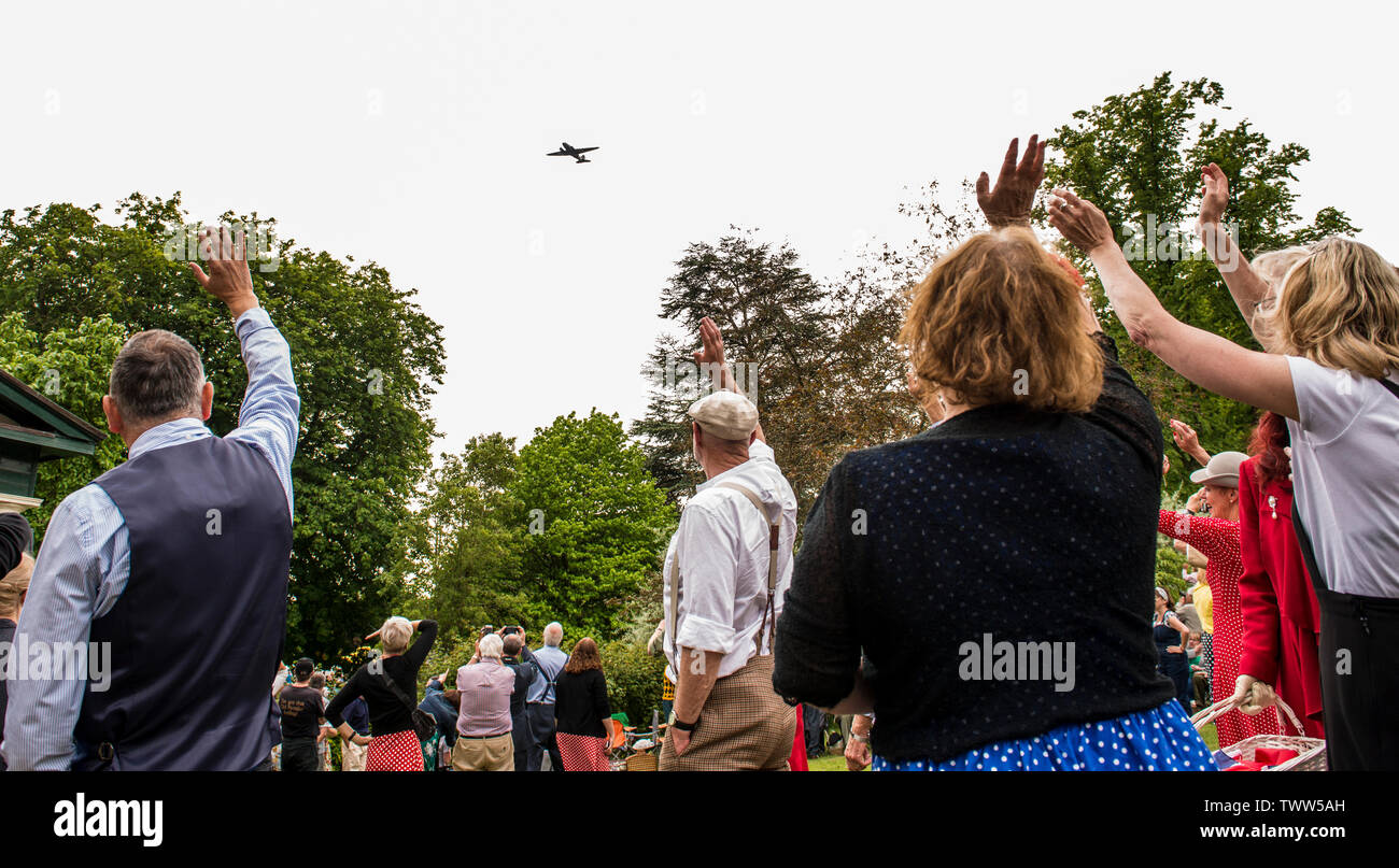 People waving as Dakota aeroplane flies past in the Valley Gardens on 1940s Day, Harrogate, England, UK, 23rd June 2019. Stock Photo