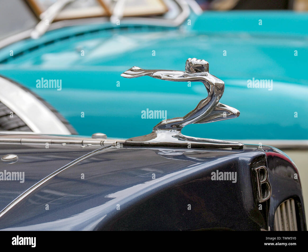 A Flying Lady hood ornament on a dark blue Bentley motor car. Stock Photo