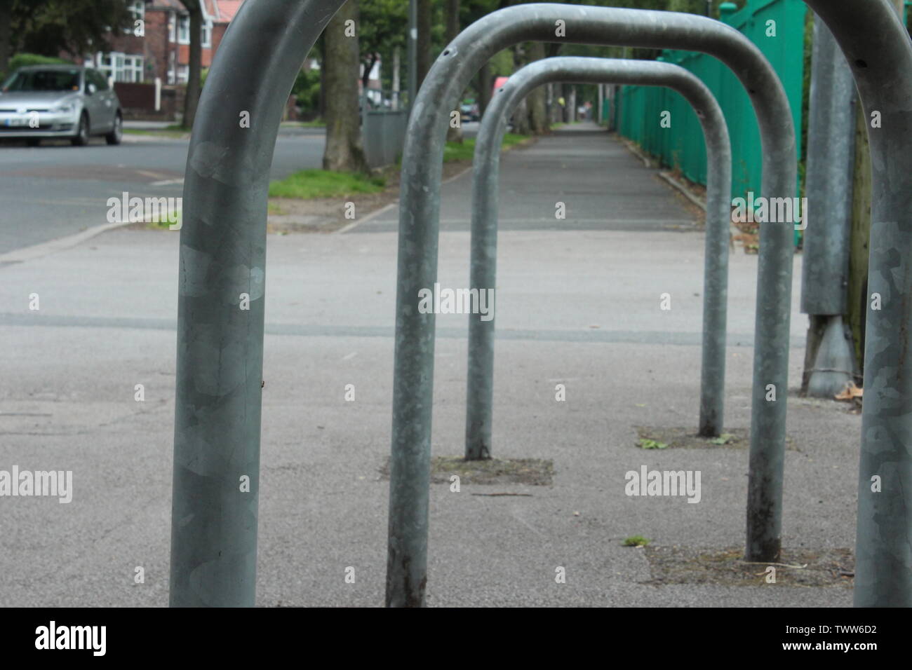 Close up of bicycle racks next to a park in an estate on a cloudy day Stock Photo