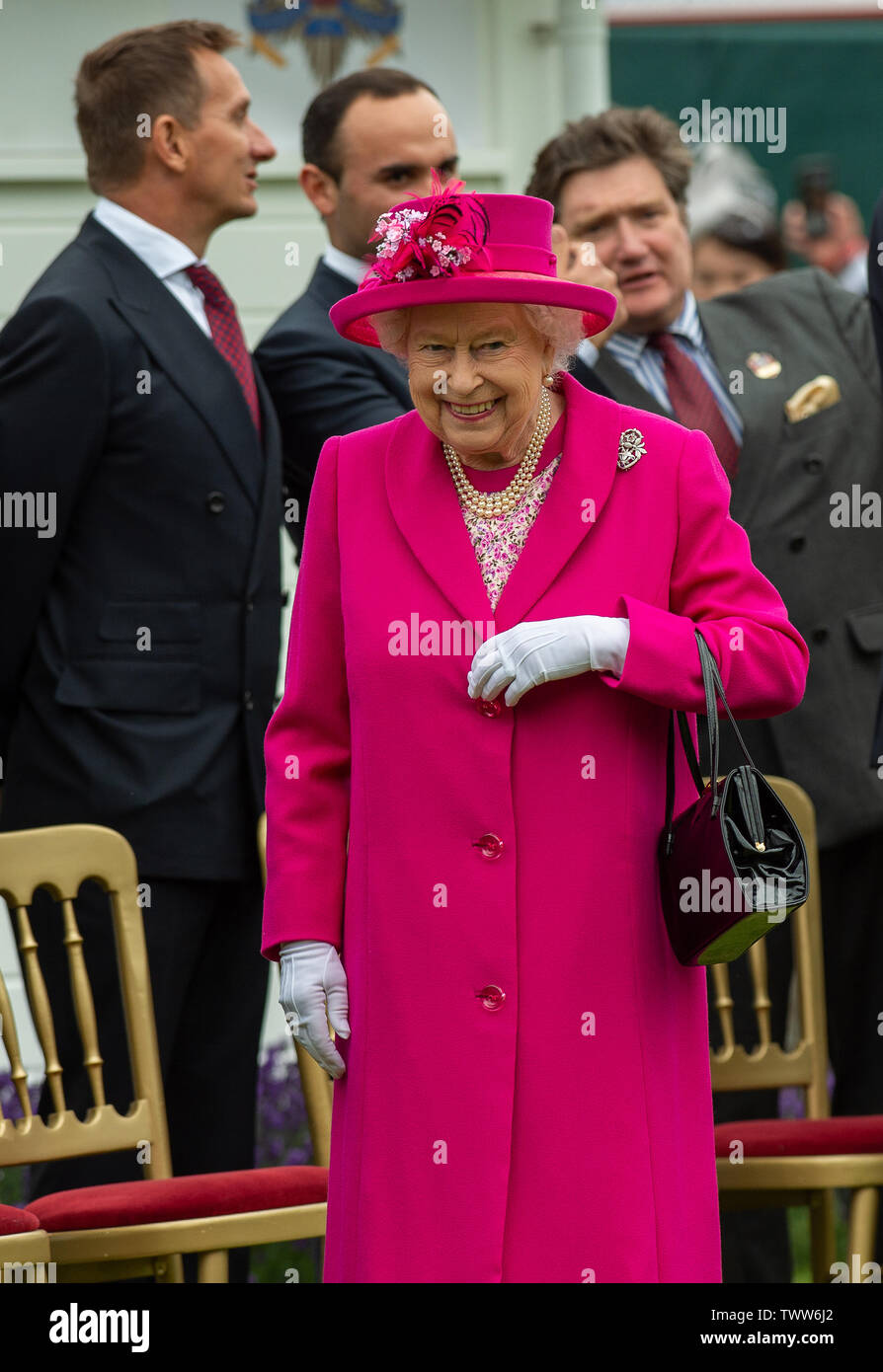 Windsor Great Park, Egham, Surrey, UK. 23rd June 2019. Her Majesty the Queen looks radiant in a bright pink shift coat and hat after posing for a photo with the Board of Directors of  Guards Polo Club. Credit: Maureen McLean/Alamy Live News Stock Photo