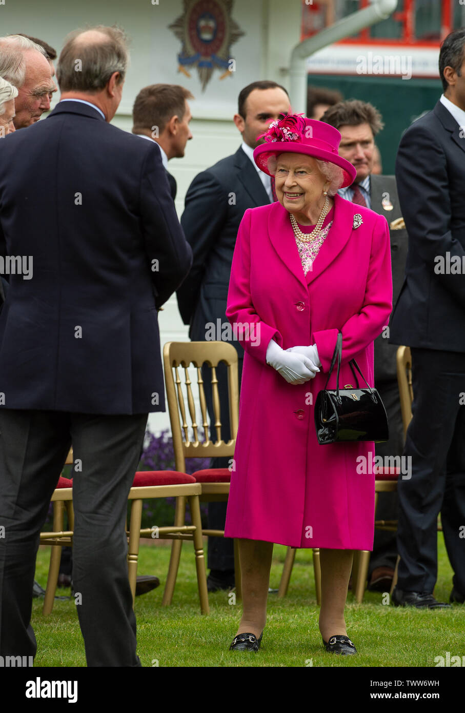 Windsor Great Park, Egham, Surrey, UK. 23rd June 2019. Her Majesty the Queen looks radiant in a bright pink shift coat and hat as she chats to the Directors of  Guards Polo Club. Credit: Maureen McLean/Alamy Live News Stock Photo