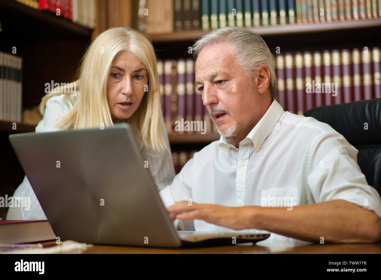 People using a laptop computer in their office Stock Photo - Alamy