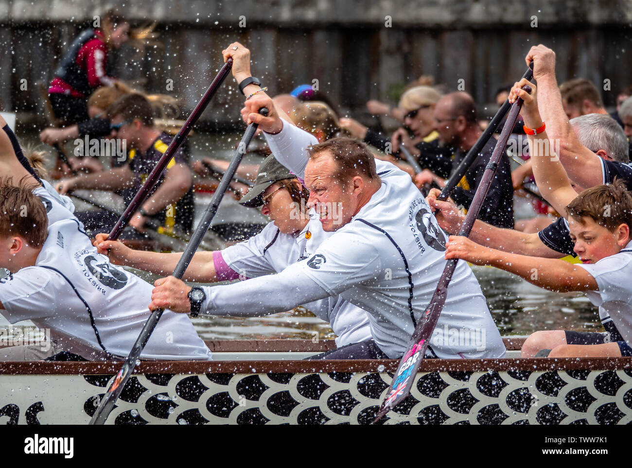 Dragon boat racing on Bristol floating harbour where teams of amateur rowers frantically paddle decorated canoes to raise money for charity Bristol UK Stock Photo