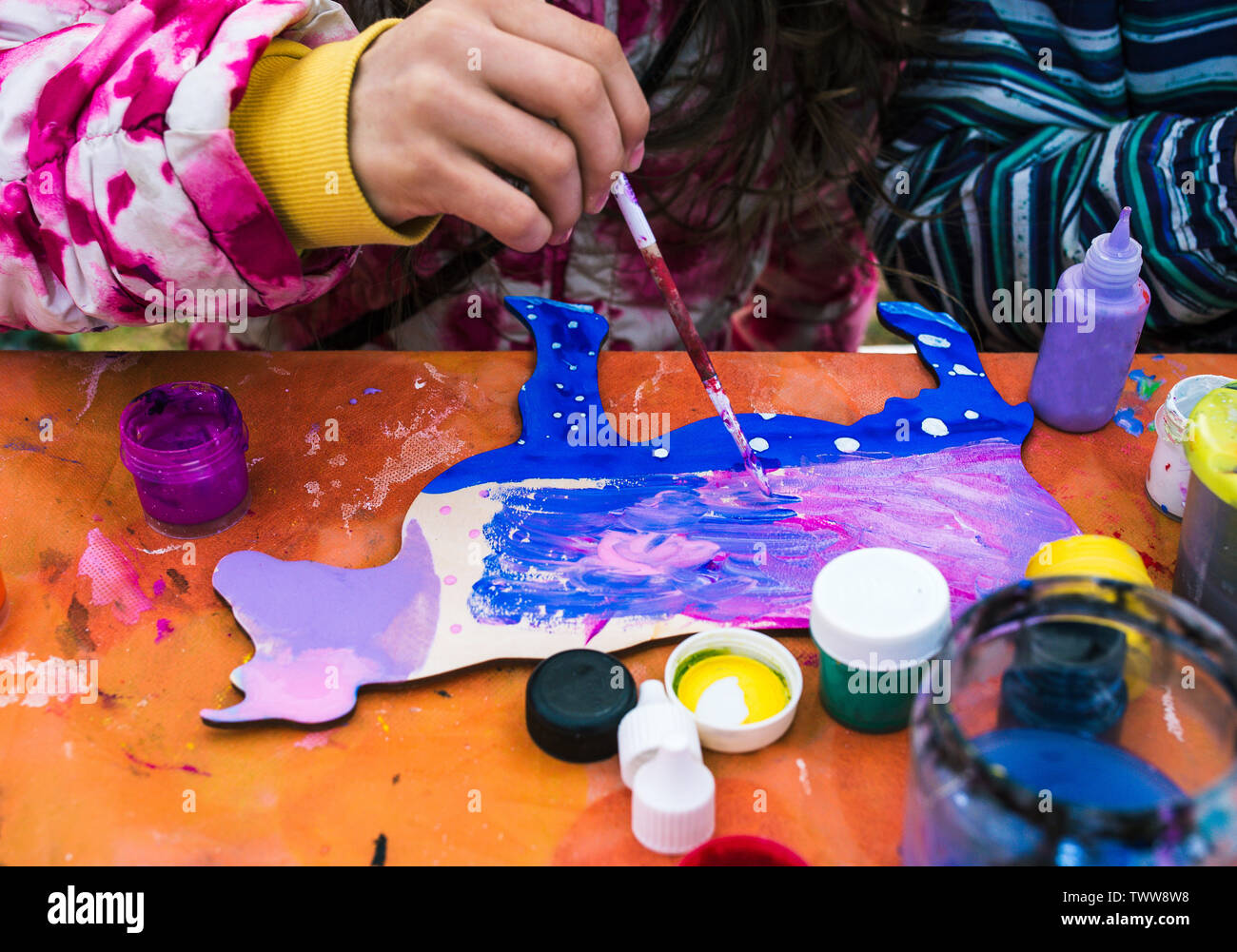 Russia, Yaroslavl city - May 4, 2019:The child paints a picture. Drawing lesson at school or creative studio. Around there are paints and cans of Stock Photo