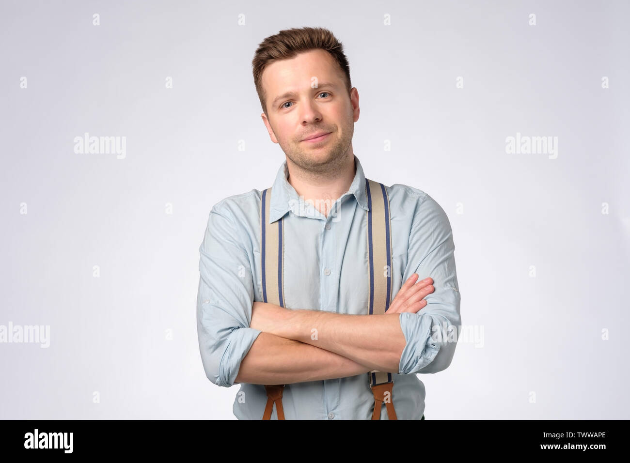 Portrait of customer in white shirt and blue suspenders in tailors boutique  stock photo